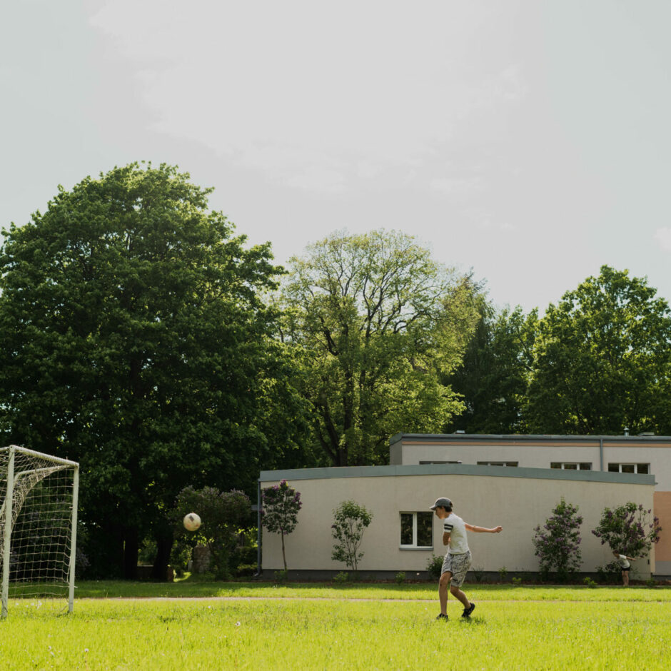 Zēns sit futbola bumbu vārtos